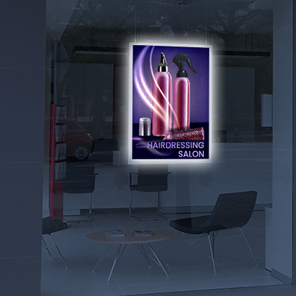 Oplyst LED plakatramme med frisørsalon udsmykning om natten