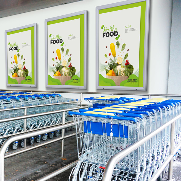 Tre plakatrammer med lås viser "Healthy Food" over rækker af indkøbsvogne foran en butik.