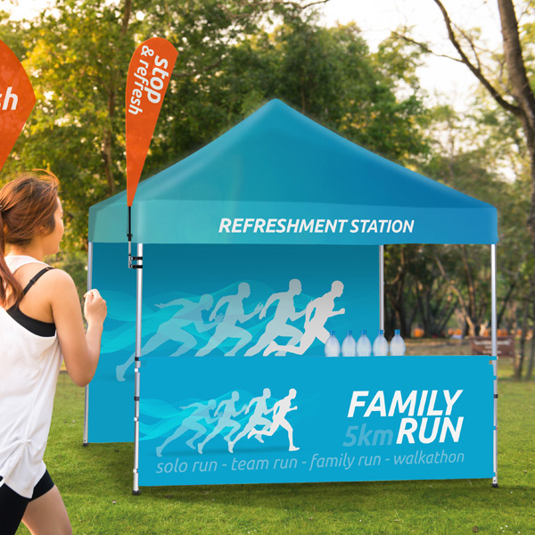 Eventtelt til løb med forfriskningsstation, "Family 5km Run" banner og BeachFlag